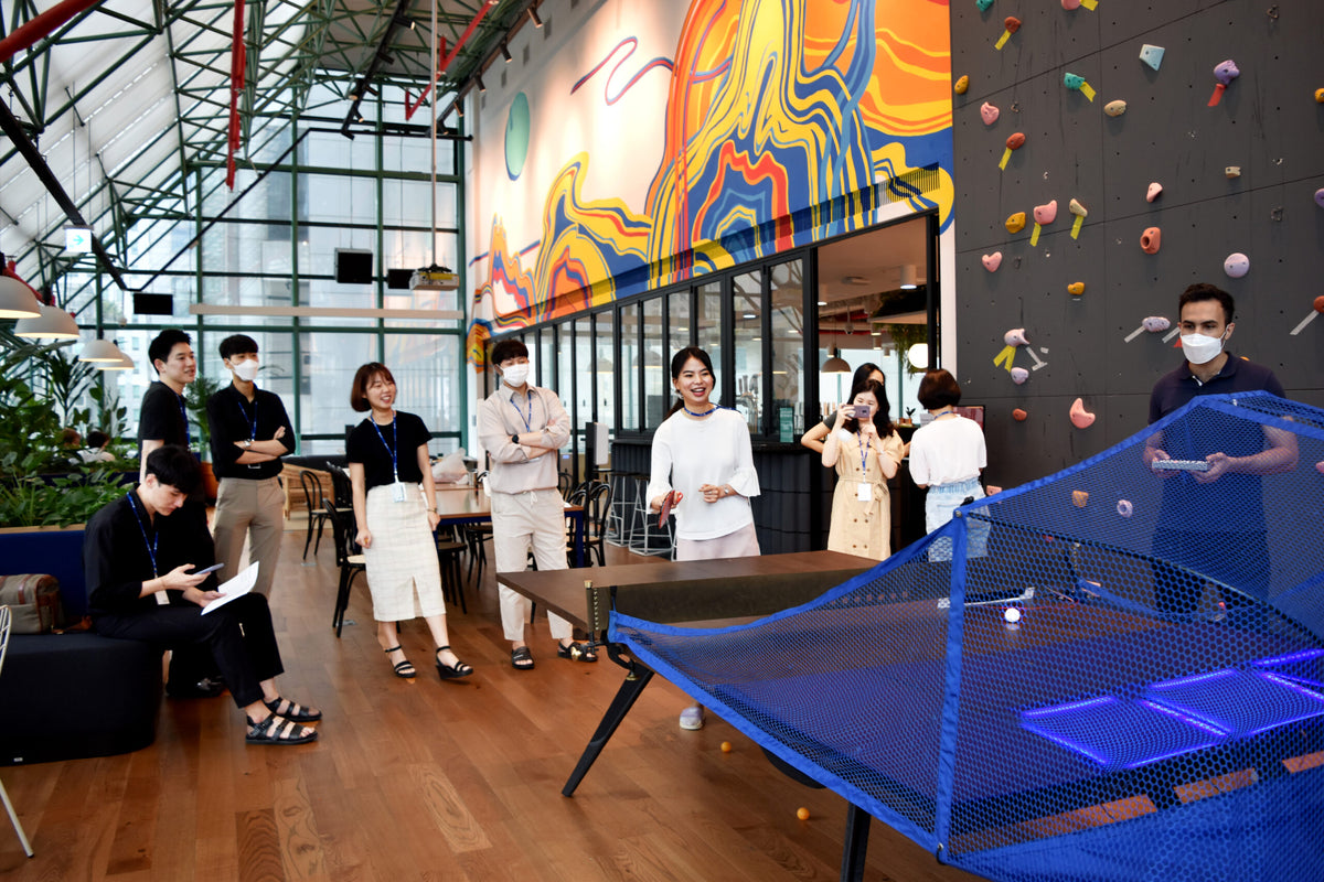 People having fun playing games on a Fastpong system in a leisure area.