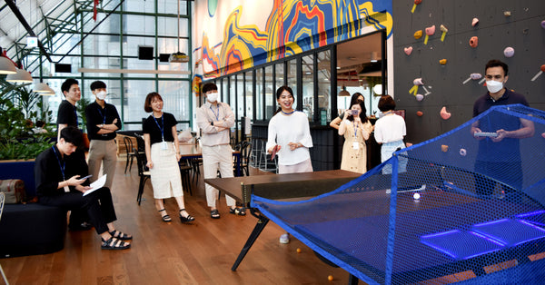 People having fun playing games on a Fastpong system in a leisure area.